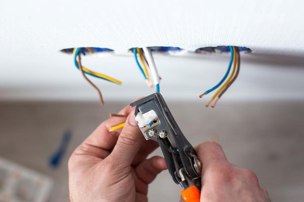 électricien dénudant l'isolation d'un fil